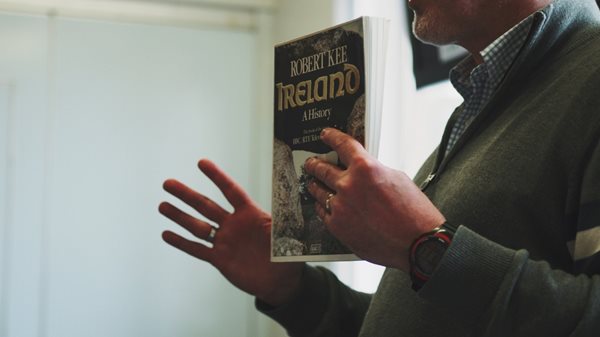 A man holding a book about Irish history.
