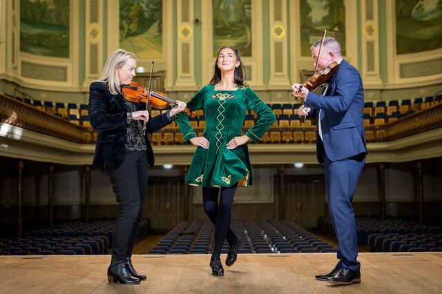 Irish dancer and two violinists on the Ulster Hall stage