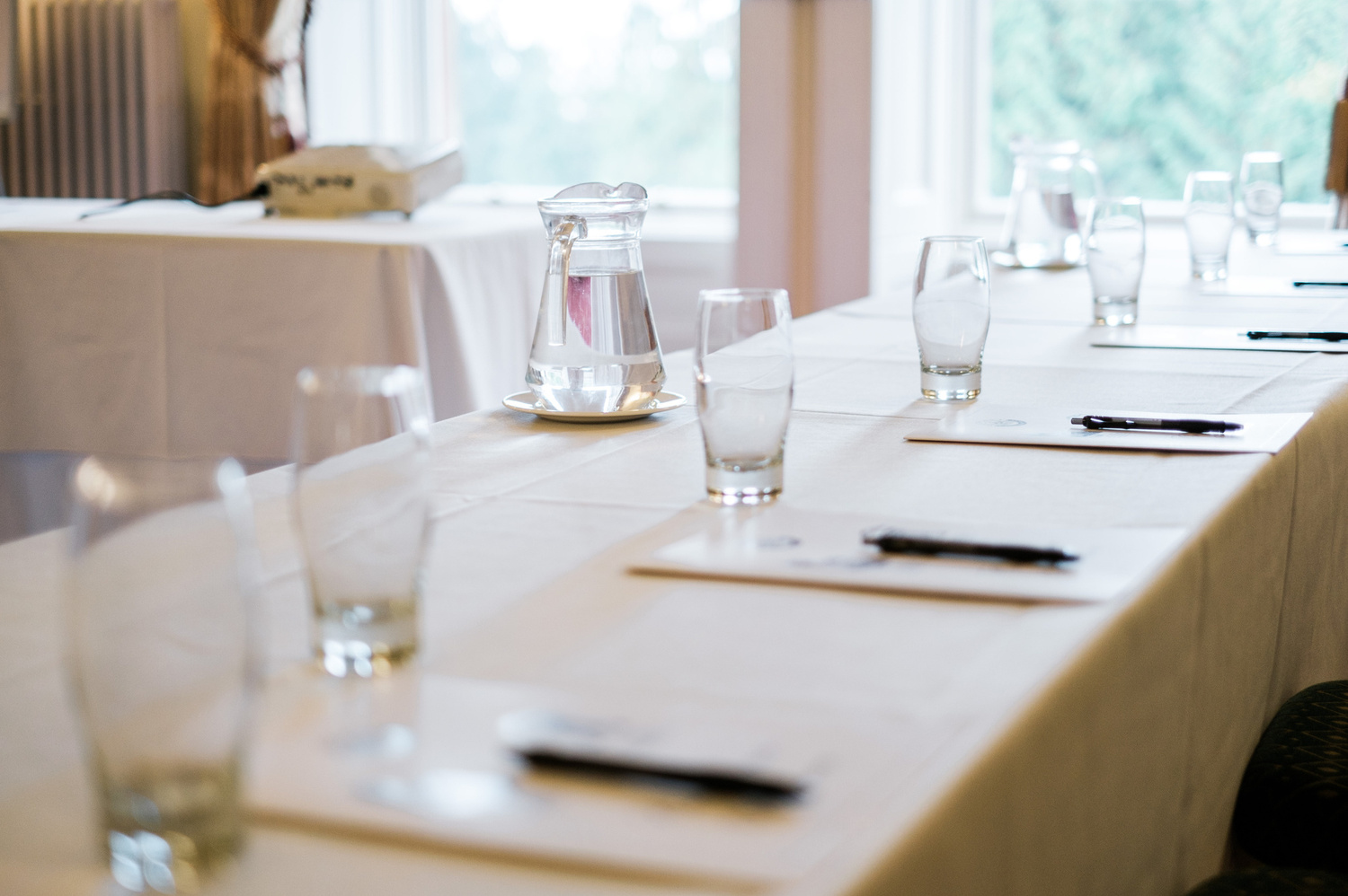 A room set up with water and glasses for a business event.