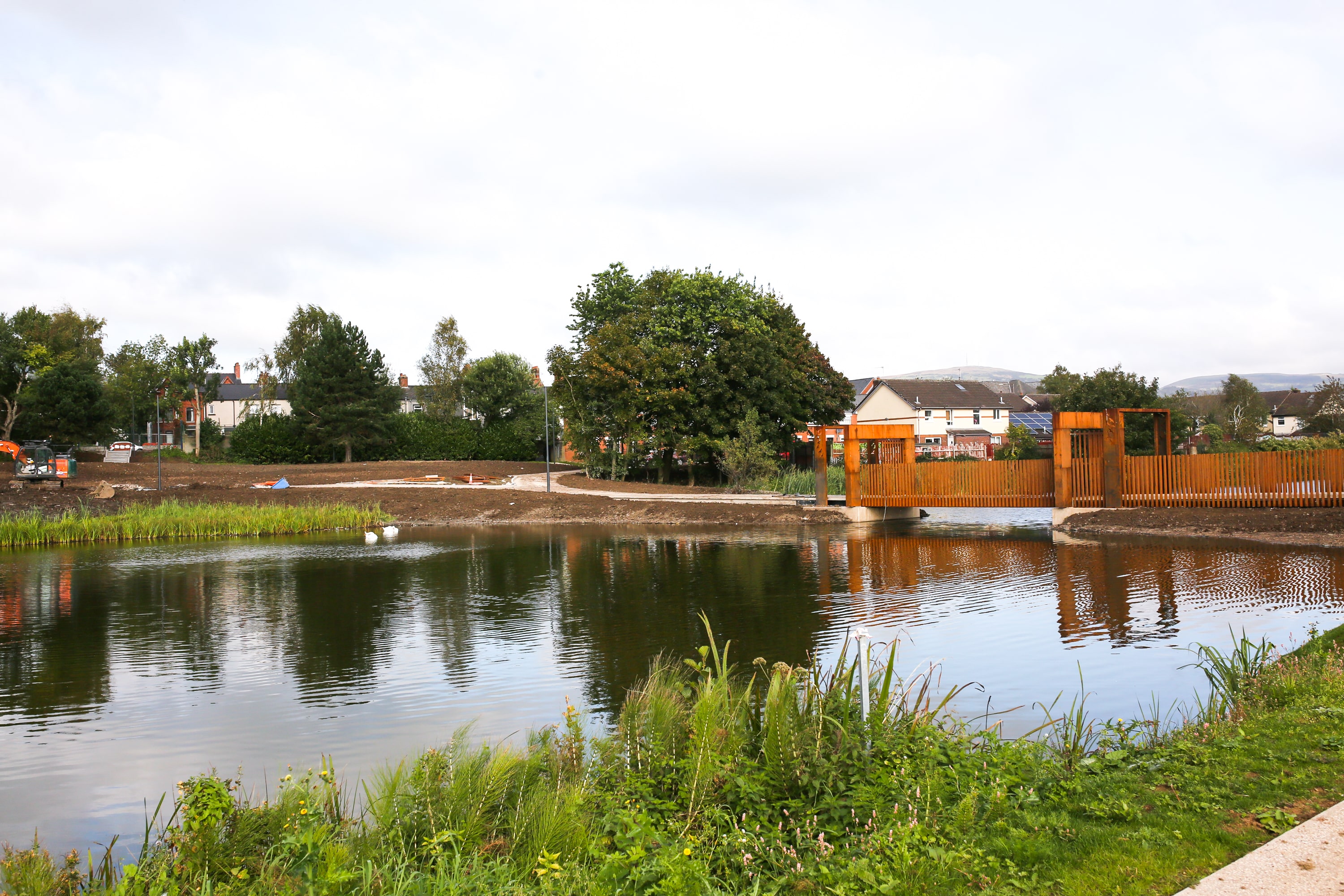 A river with a bridge over it in Springfield Dam park in Belfast.