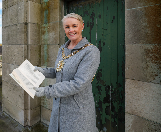 Lord Mayor Councillor Tracy Kelly pictured on the roof of the building that will become Belfast Stories with a book in her hand.