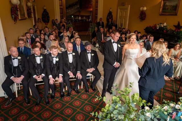A wedding ceremony in the Donegall Room with Bride and Groom at the top of the aisle while guests watch on in a theatre-style set up. 