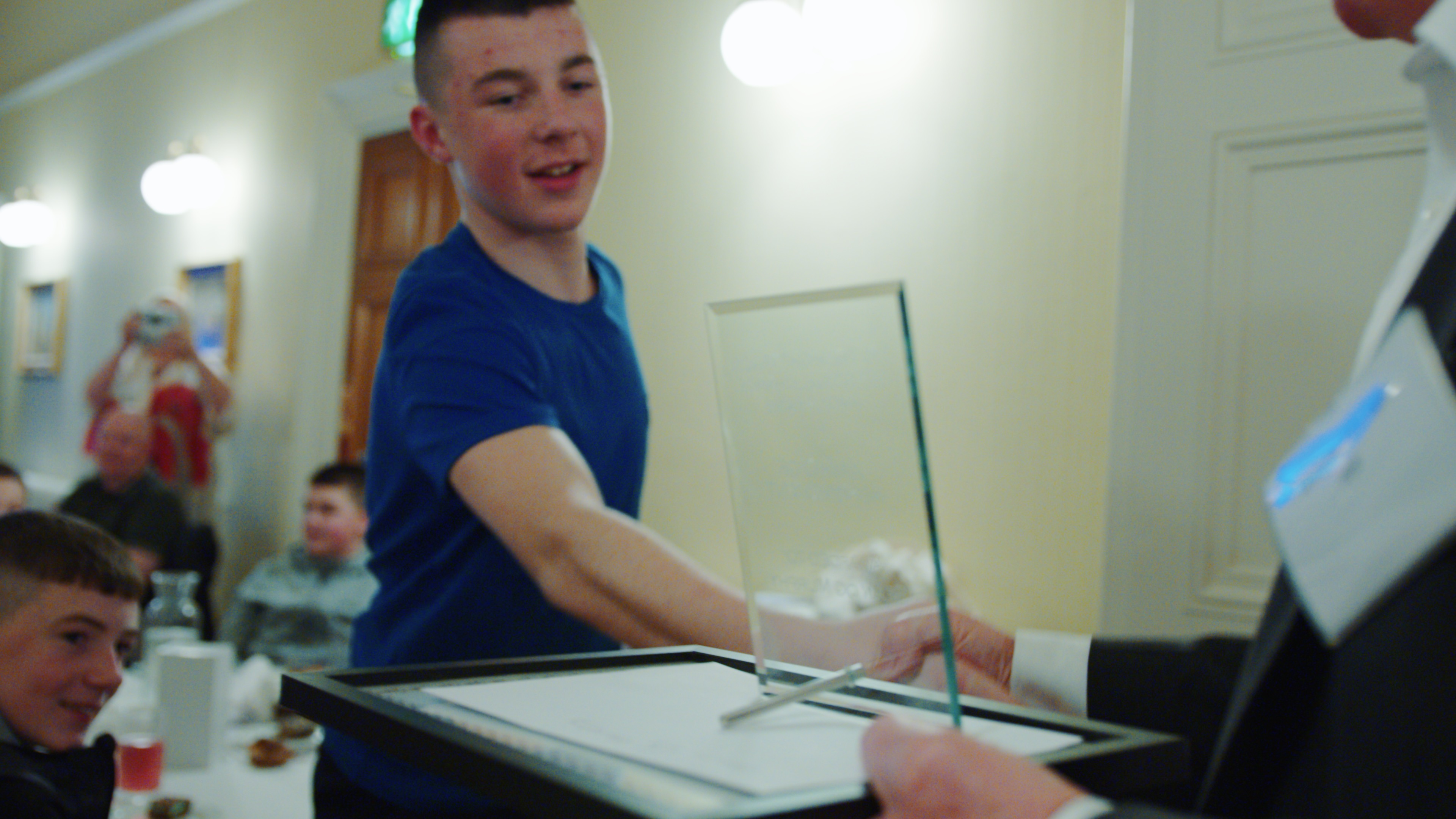 A boy receiving a trophy during an awards ceremony.