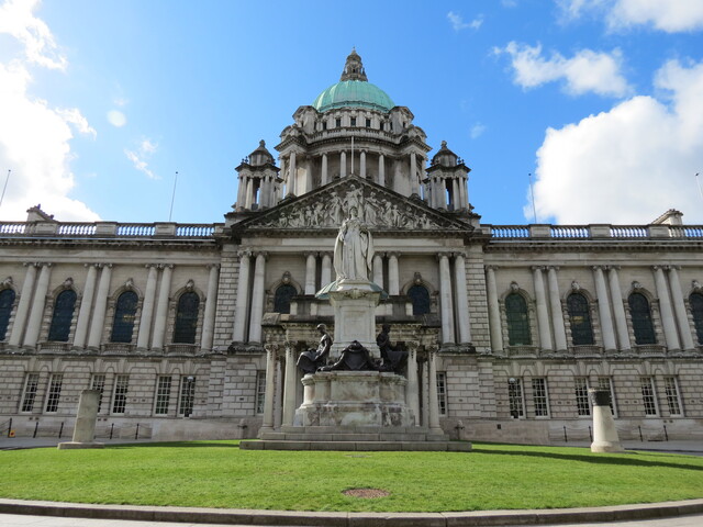 Front of Belfast City Hall building showing green lawn 