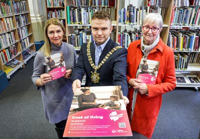 Ciara Gault from Libraries NI, Lord Mayor Councillor Ryan Murphy & Rita Murray from Greater Belfast Seniors Forum holding cost of living guides at Belfast Central Library