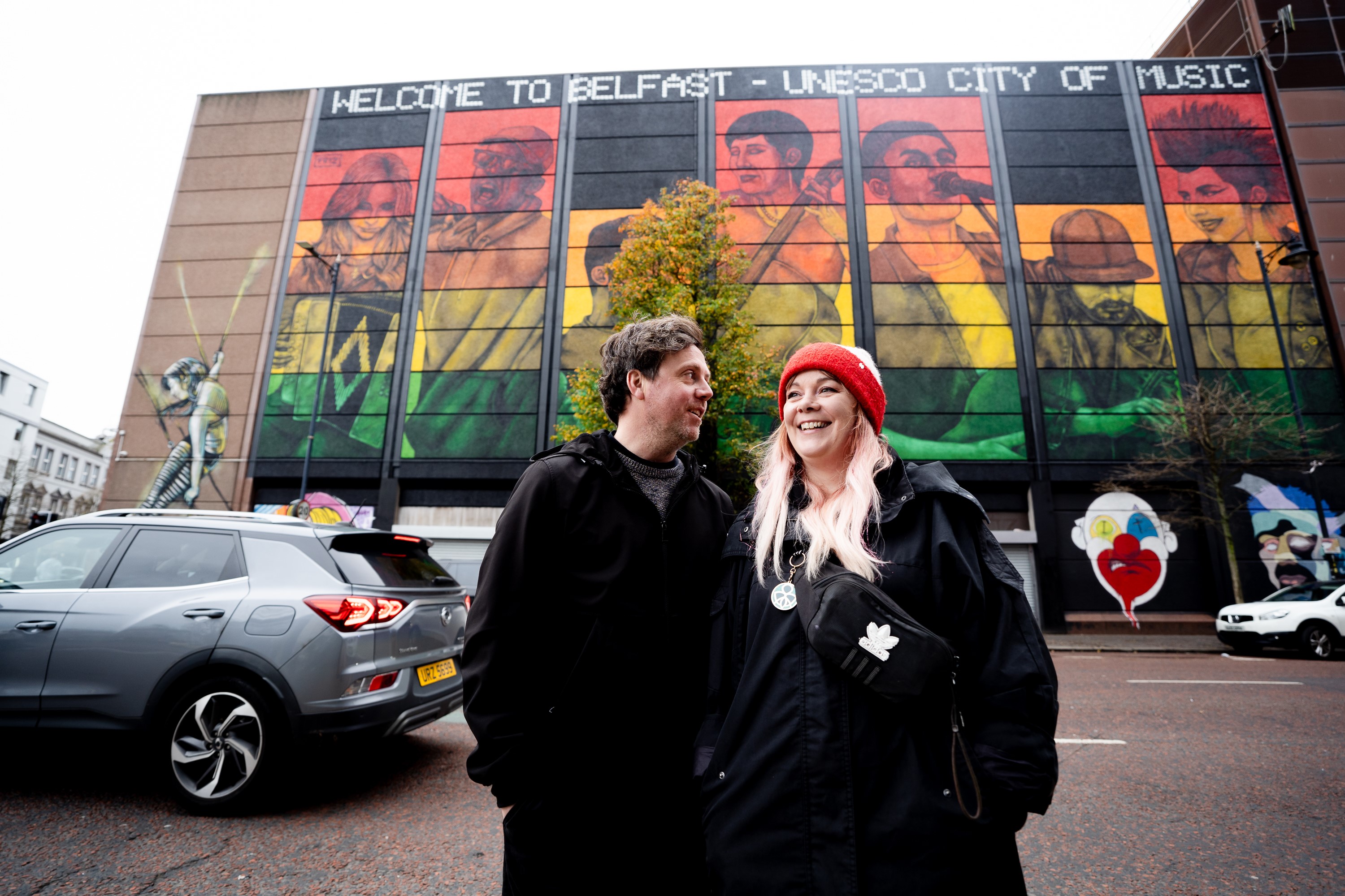 Mural artists Friz (Marian Noone) and Gerry Norman in front of new UNESCO City of Music mural on the Telegraph Building.