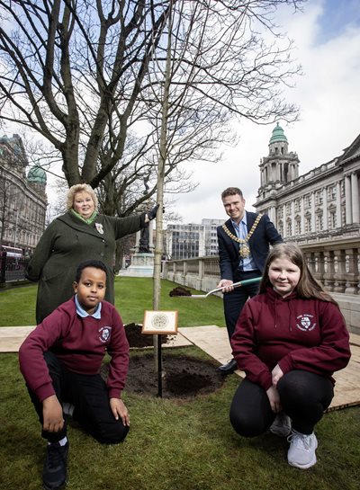 Lord Mayor of Belfast and Lord Lieutenant of Belfast plant a tree to mark the King's coronation with pupils from Fane St Primary School at City Hall.