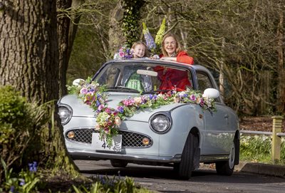 Lord Mayor Tina Black with little girl inside a spring-decorated vintage car.