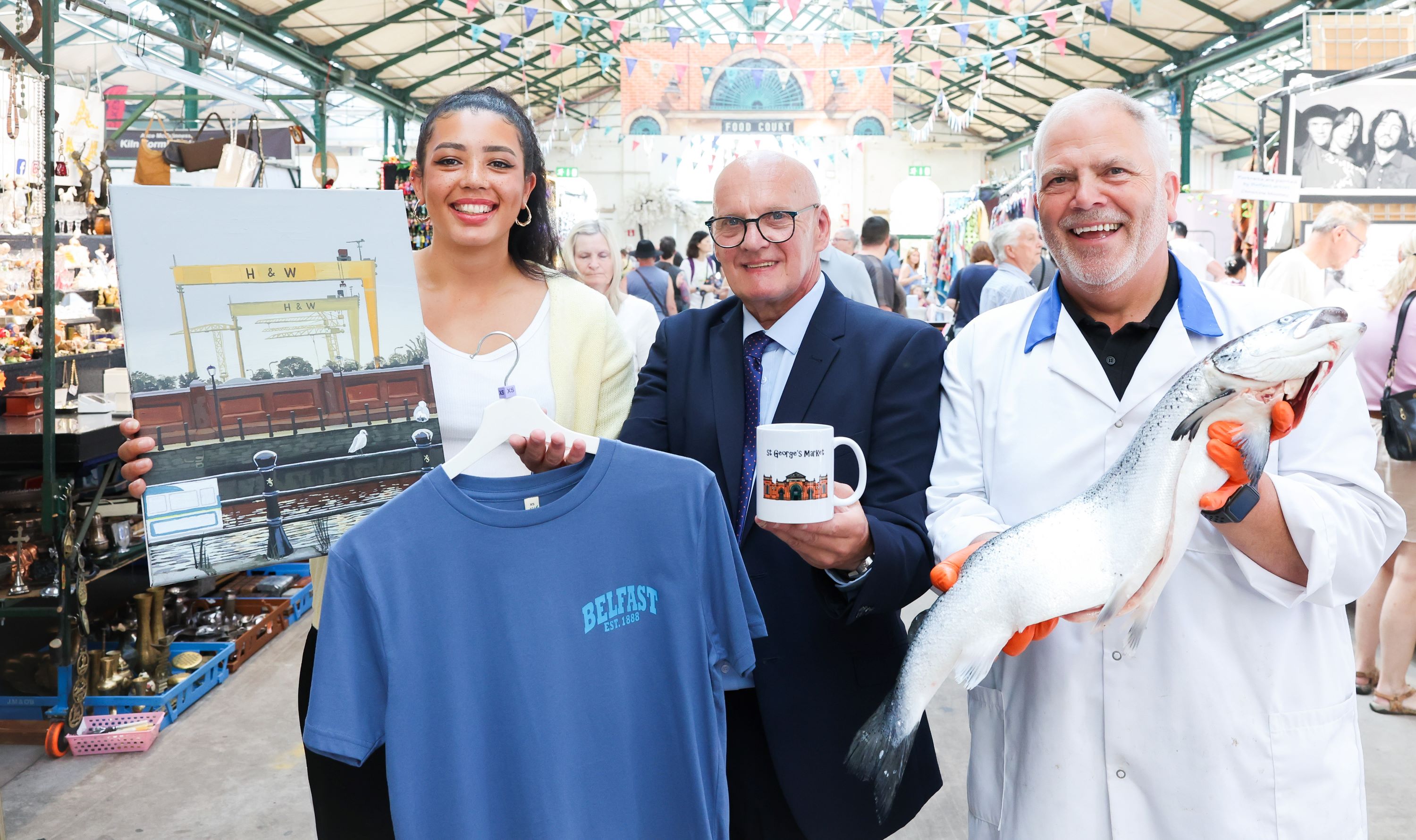 Councillor Ian McLaughlin, Chair of City Growth and Regeneration Committee is joined by artist Anna McDonald-Anakaa and fishmonger David Cully at St George's Market.