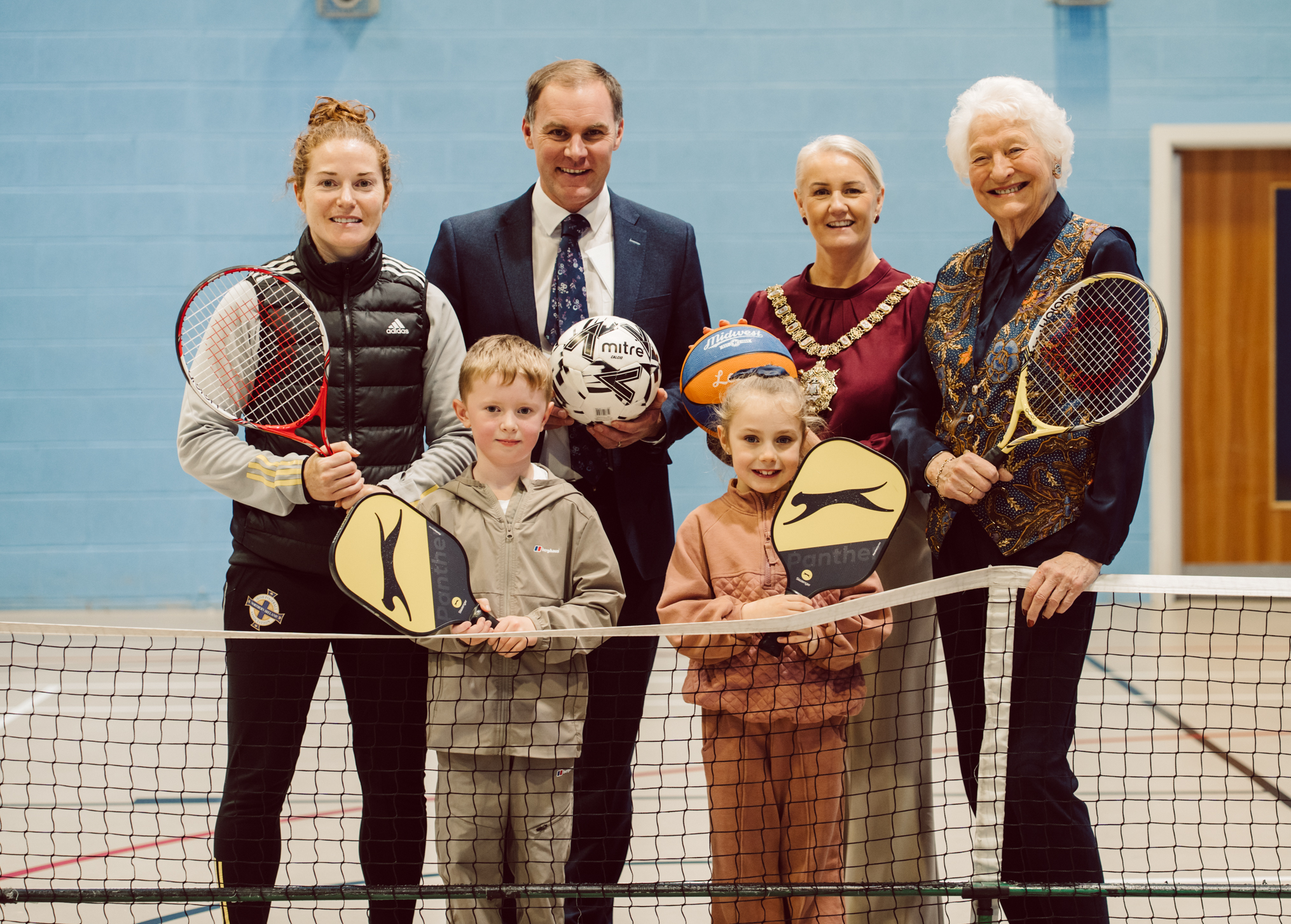 Footballer Marissa Callaghan, Gareth Kirk (GLL), Lord Mayor of Belfast, Councillor Tracy Kelly, and Lady Mary Peters are joined by young athletes to mark Belfast's European City of Sport 2026 title.