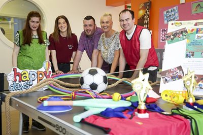 Lord Mayor of Belfast, Councillor Tracy Kelly, with Happy Days users, surrounded by sports props and equipment.