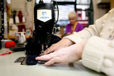 Close up of a female using a sewing machine to mend clothes.