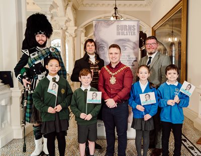 Four schoolchildren with Lord Mayor Ryan Murphy, Ian Crozier from Ulster-Scots Agency, a bagpiper and actor Christopher Tait as Robert Burns