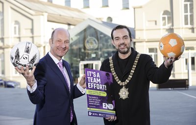 BBC presenter Stephen Watson and Lord Mayor of Belfast, Councillor Micky Murray, launch It’s a Team Effort sports conference. They are pictured holding sports equipment and an event poster.