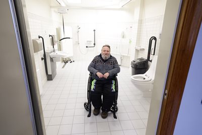 Man in a wheelchair inside a Changing Places toilets facility