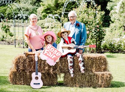 Children with cowboy hats and guitars sat on hay bails with Belfast Lord Mayor Tracy Kelly and Arthur Dixon from the Rose Society of Northern Ireland stood behind
