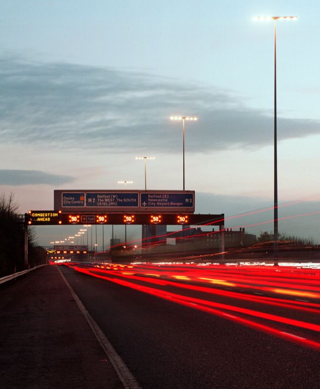Red car headlights streaked along M2 Motorway in Belfast city centre.