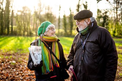 older couple in park, lady holding a small sapling