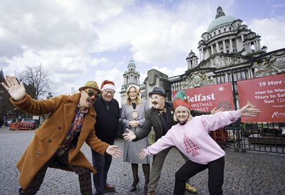 Lord Mayor Councillor Christina Black with group of people standing outside Belfast City Hall where the Christmas Market is taking place.