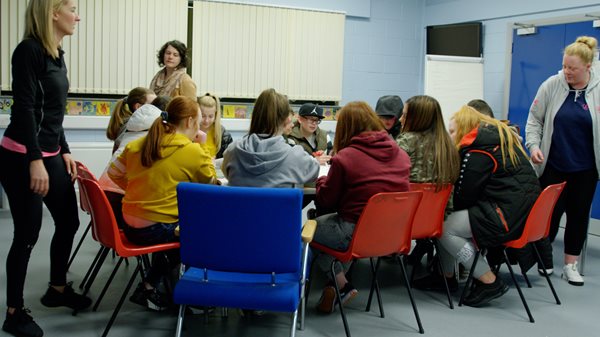 A group of children in a classroom taking part in
