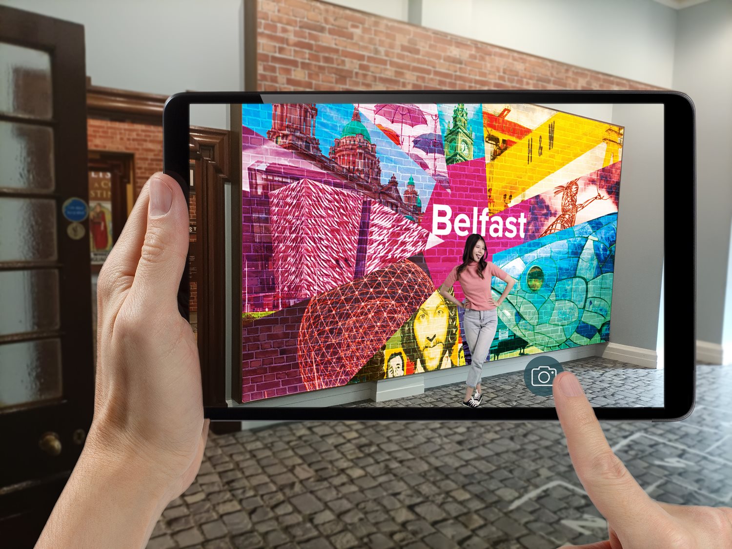 A photograph of someone holding an iPad, through which they are viewing an augmented reality experience around them