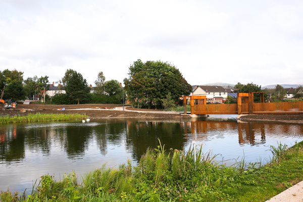 A river with a bridge over it in Springfield Dam park in Belfast.