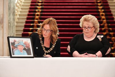 White flowers sitting on top of an open book of condolence.
