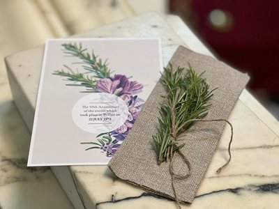 Event programme with a sprig of rosemary sitting on a piece of Belfast linen.