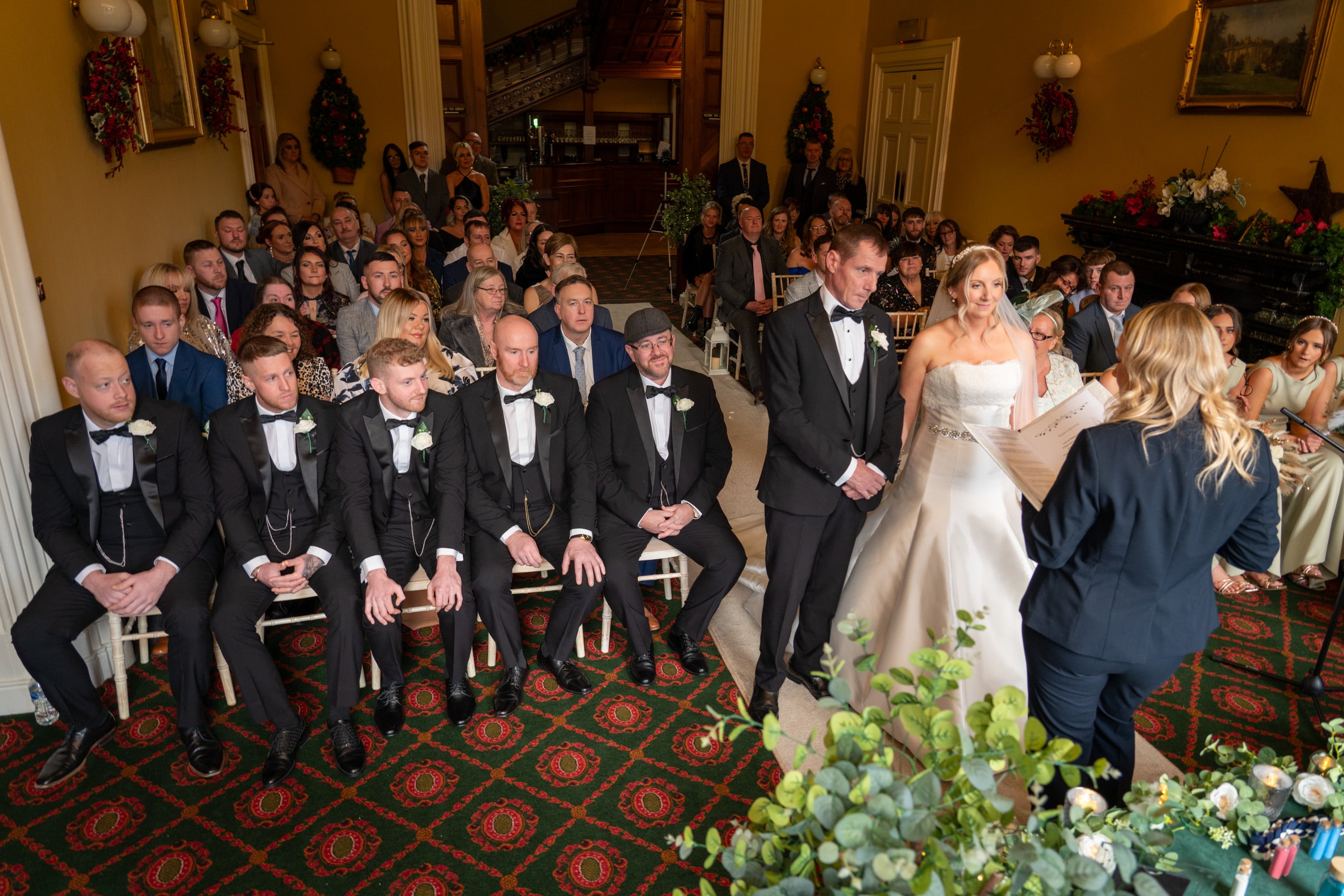 A wedding ceremony in the Donegall Room with Bride and Groom at the top of the aisle while guests watch on in a theatre-style set up. 