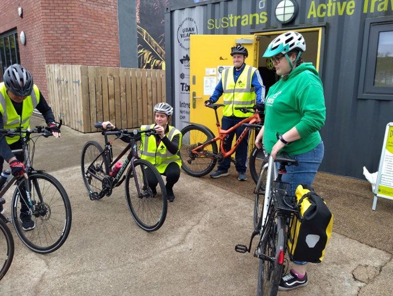 Group of cyclists checking their bikes before beginning cycle training at Sustrans Active Travel Hub at CS Lewis Square, east Belfast.
