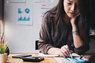 Woman at a desk reading financial information